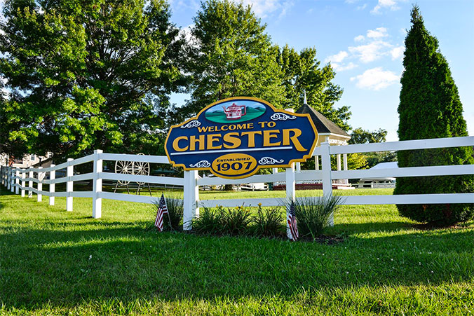 Sign on white fence that reads Welcome to Chester WV